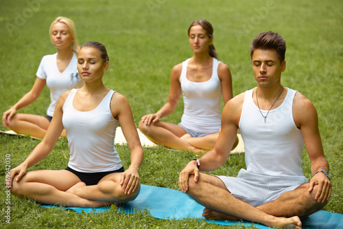 Yoga Class. Group of People Meditating At Summer Park © puhhha
