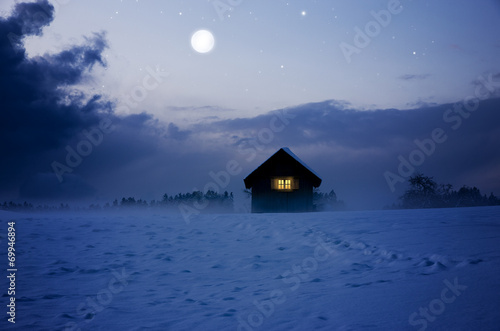 Beleuchtete Hütte bei Vollmond