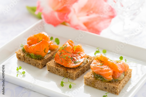 Delicious appetizer canapes of black bread with smoked salmon