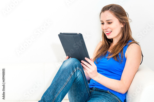 young woman on the couch with her tablet © ilolab
