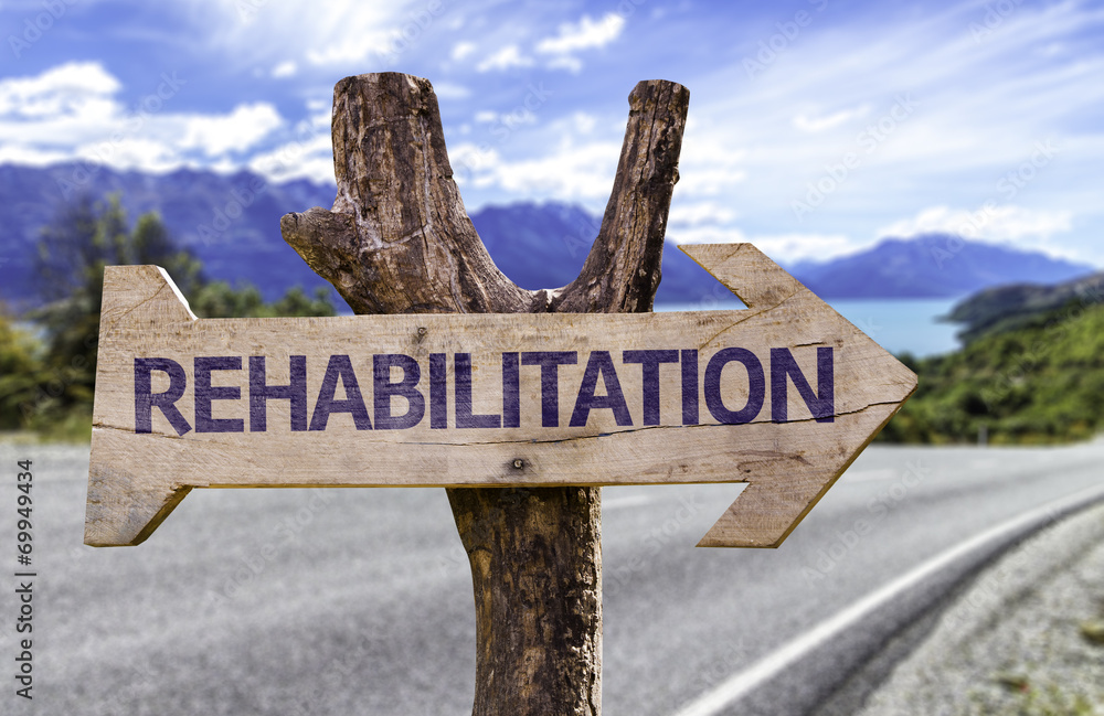 Rehabilitation wooden sign with a road background