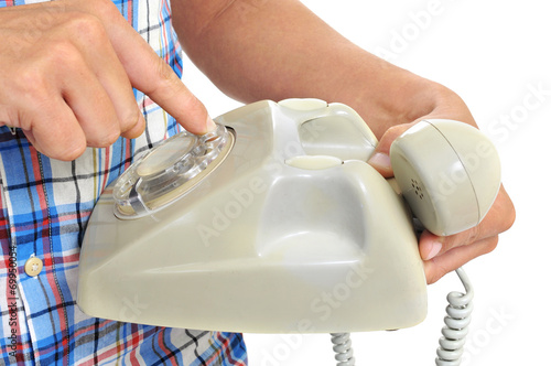 young man dialing in a rotary dial telephone
