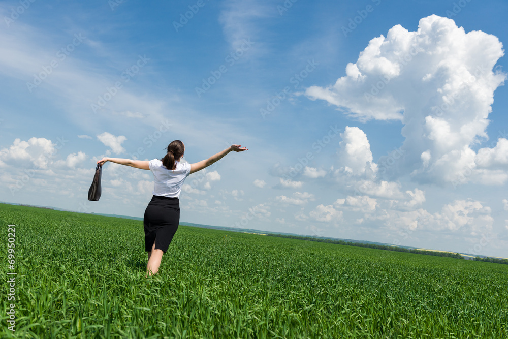 woman with a briefcase walking on the grass woman with a briefcase walking on the grass