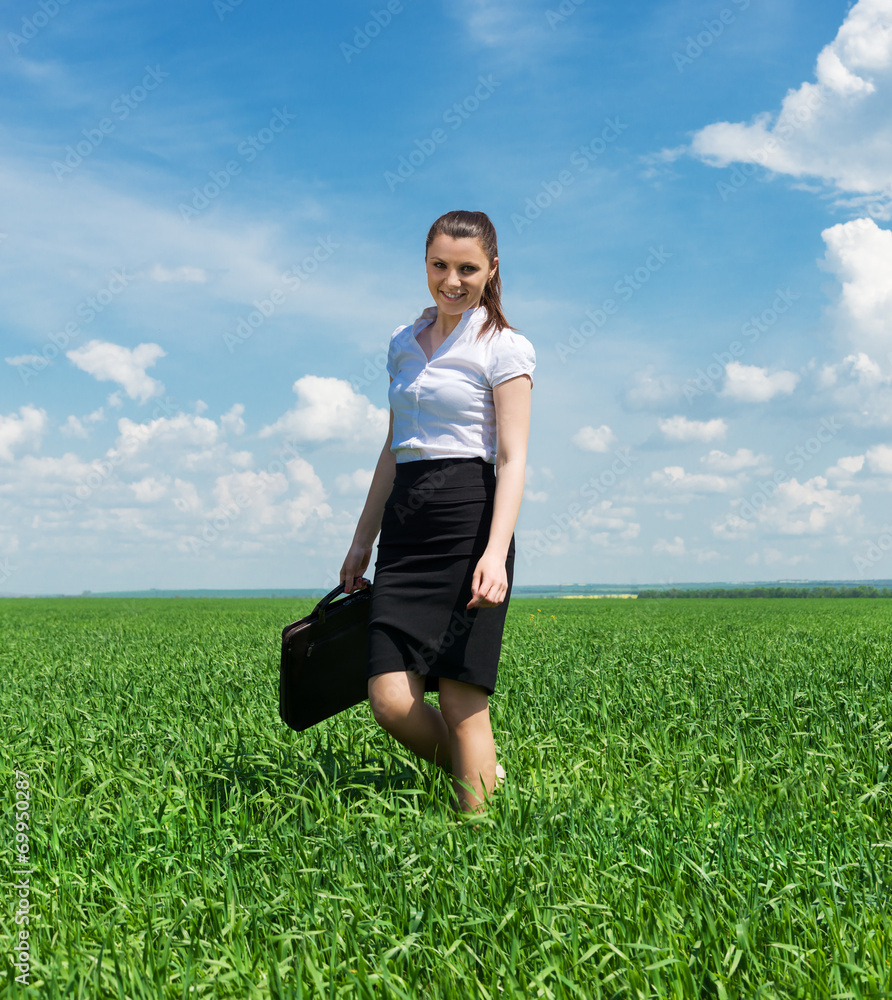 woman with a briefcase walking on the grass