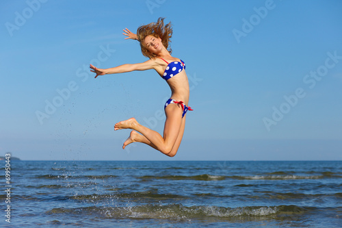 cheerful girl jumping at sea