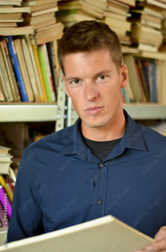 Young man reading a book in the library Young man reading a book in the library