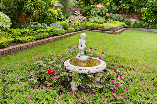 Statue of a boy with fountain in the gardern photo