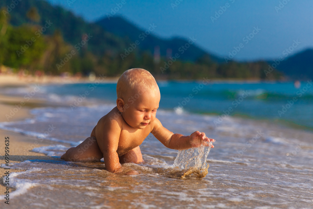 A little kid having fun on a tropical beach. A little kid having fun on a tropical beach.