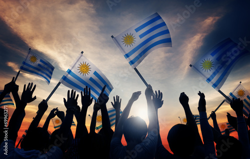Silhouettes of People Holding Flag of Uruguay photo