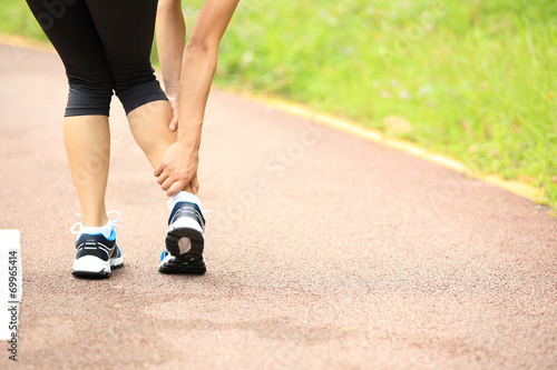 woman runner hold her sports twisted ankle