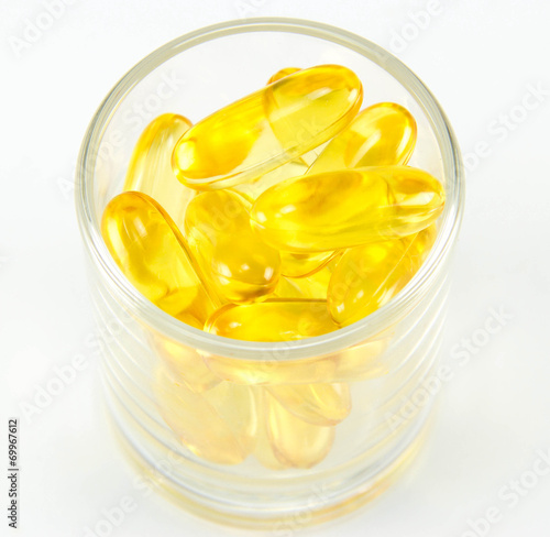Healthy vitamin glass : yellow oil pills in translucent glass