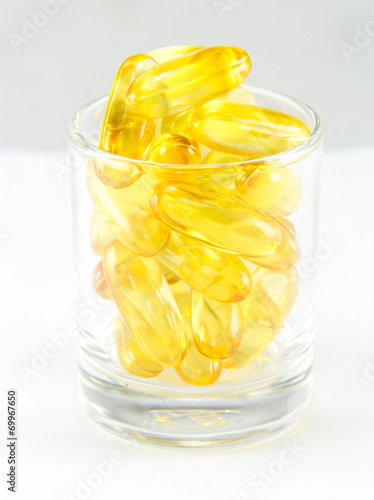 Healthy vitamin glass : yellow oil pills in translucent glass