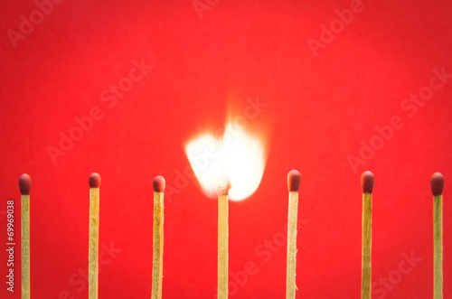 burned match setting on red background for ideas and inspiration