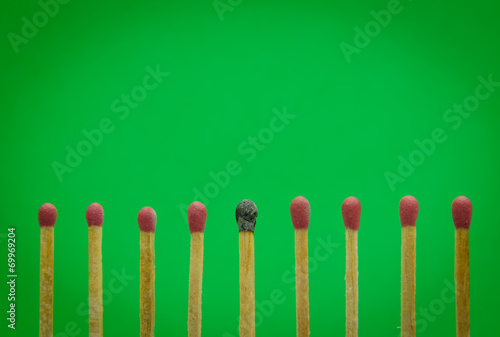 burned match setting on green background for ideas and inspirati