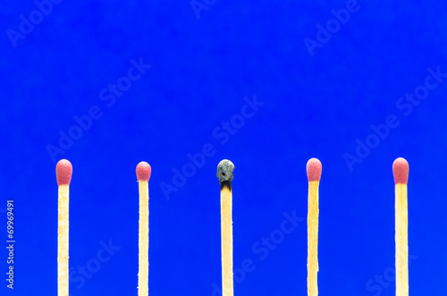 burned match setting on blue background for ideas and inspiratio