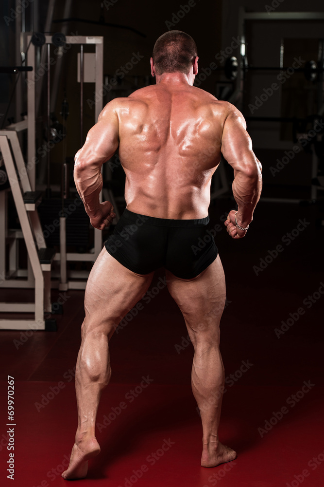 Bodybuilder Performing Rear Lat Spread Pose Bodybuilder Performing Rear Lat Spread Pose