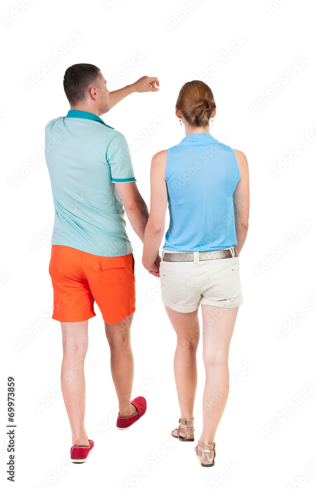 Back view of walking young couple (man and woman) pointing. Back view of walking young couple (man and woman) pointing.