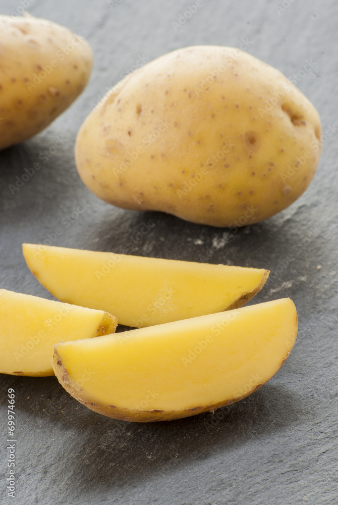 cut potatoes on black background close up