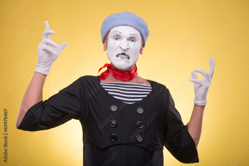 Portrait of male mime isolated on yellow background