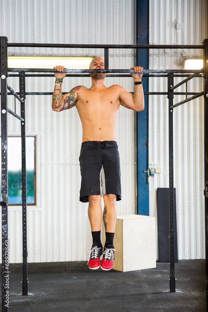 Fototapeta premium Male Athlete Doing Chin-Ups At Healthclub