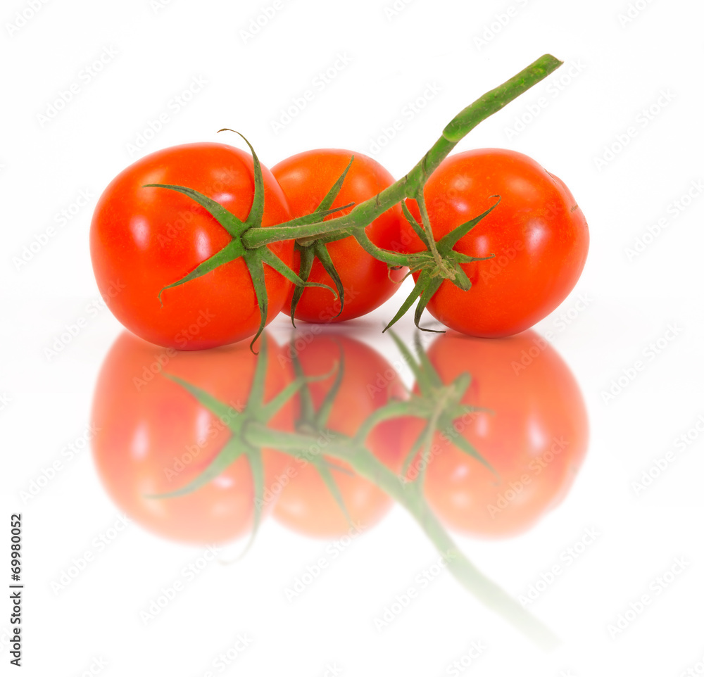 Three fresh tomatoes with green leaves isolated Three fresh tomatoes with green leaves isolated
