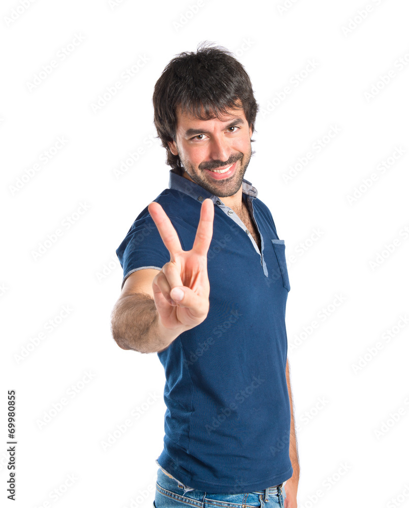 Man doing victory gesture over white background Man doing victory gesture over white background