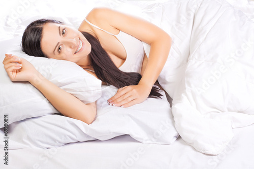 portrait of young beautiful woman in bed