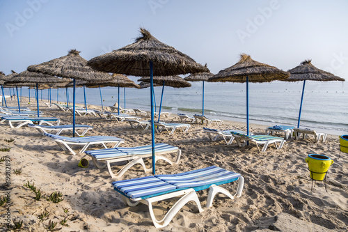 Sun umbrella on an empty beach and sea water horizon © KarSol
