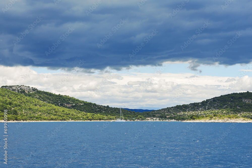 coastline of Adriatic Sea under dark blue clouds
