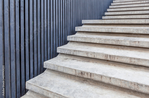 Cement stairway with blue wood wall in modern building.