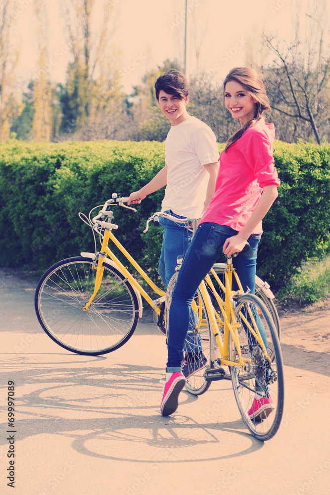 Fototapeta premium Young couple with bicycles in park