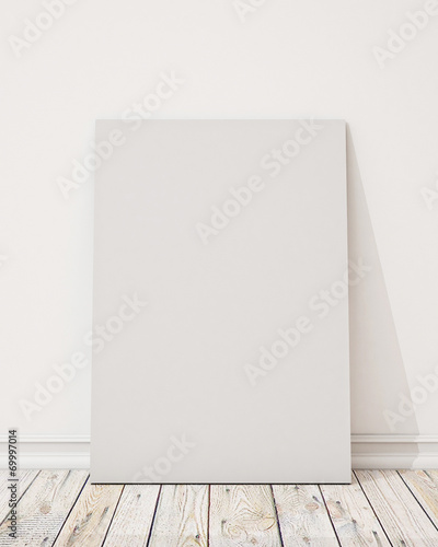 blank poster on the white wall and the wooden floor