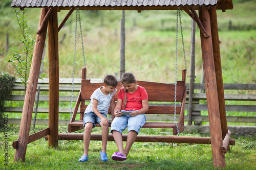 Children with tablet outdoors