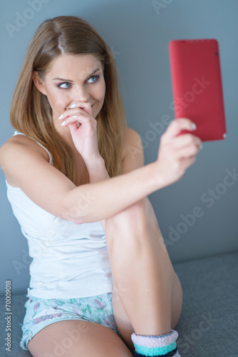 Woman Smiling and Looking Up at Tablet Computer photo