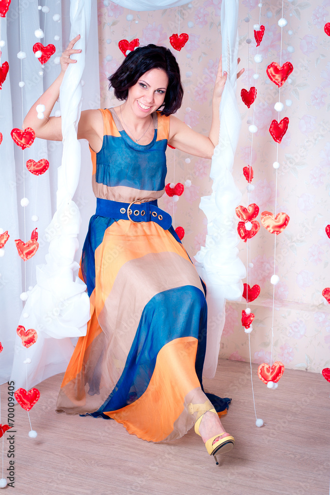 Fototapeta premium young woman on a swing with hearts
