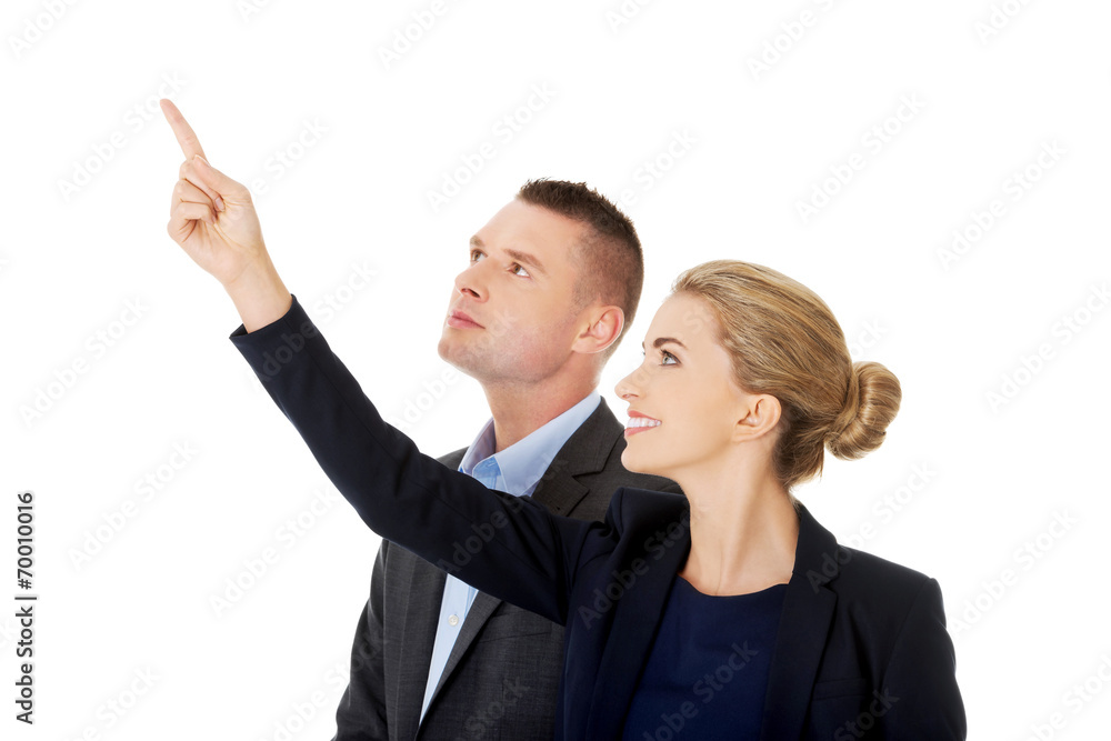Successful business couple pointing away Successful business couple pointing away