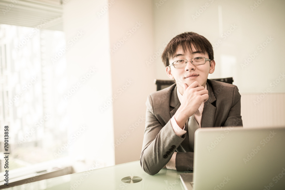 Young handsome man using laptop in his office Young handsome man using laptop in his office