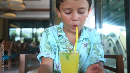 child  in a cafe drinking lemonate photo