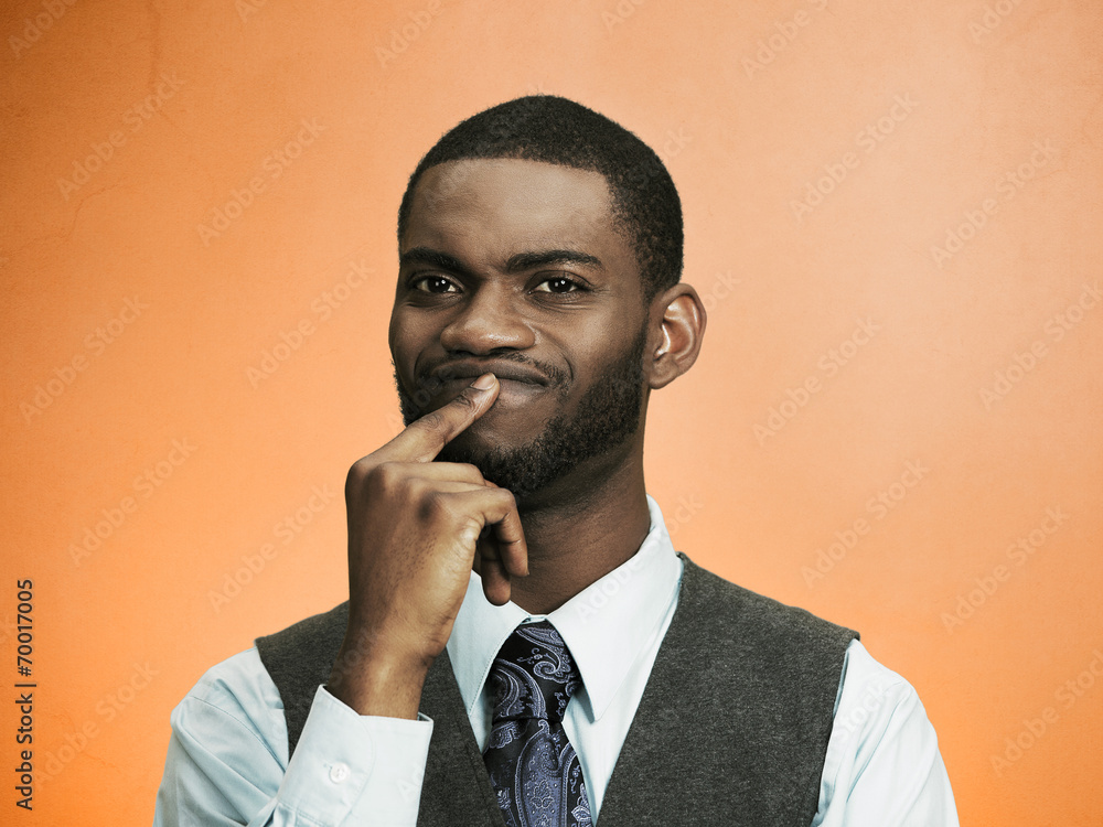 Headshot man thinking, deciding something orange background Headshot man thinking, deciding something orange background