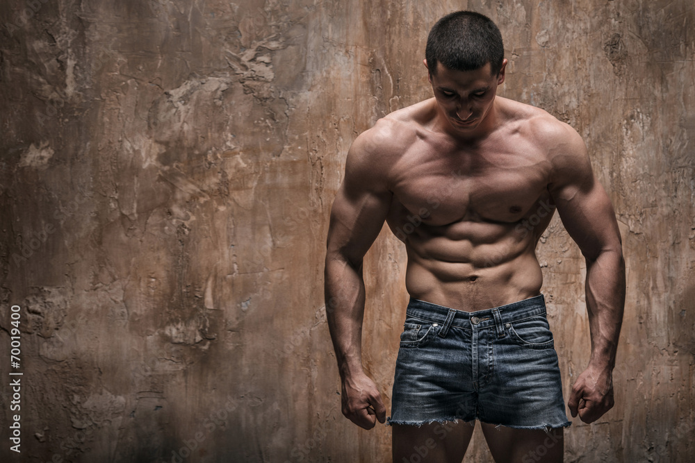 Muscular man on wall background