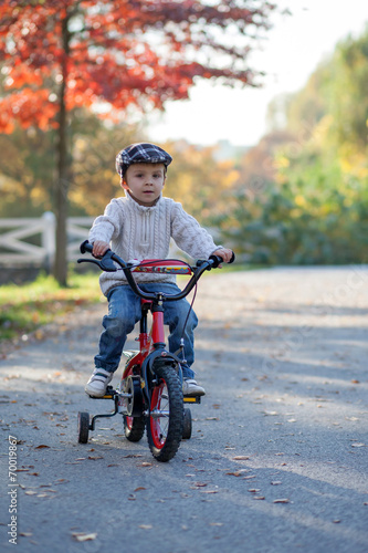 Adorable boy in the park, with his bike, learning to ride © Tomsickova