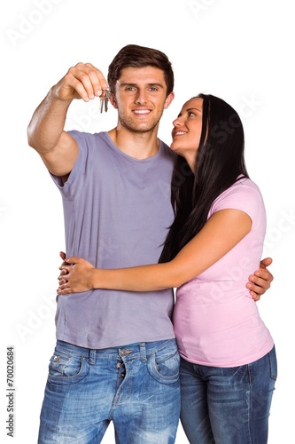 Young couple showing keys to house
