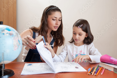 mother helping her daughter get ready for school