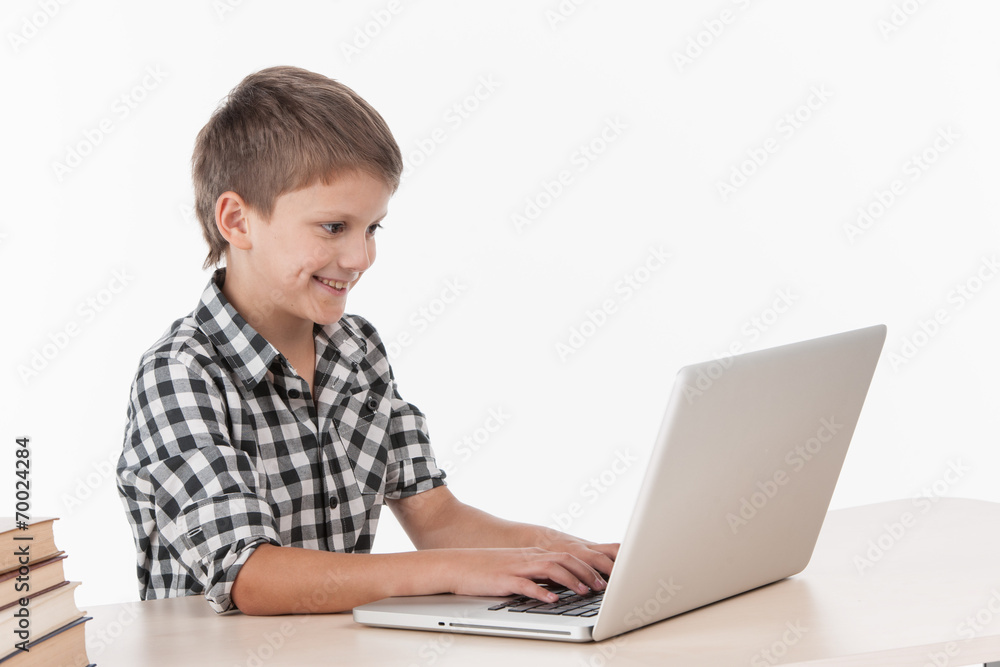 Happy little boy using laptop at table. Happy little boy using laptop at table.
