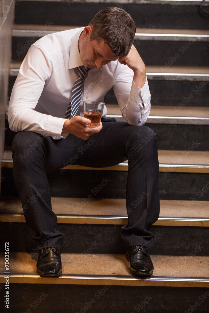 Handsome young man sitting on stairs. Handsome young man sitting on stairs.