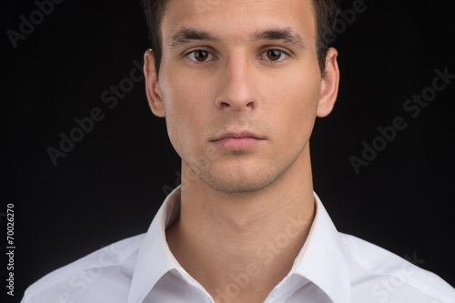 Fototapeta closeup of young man face on black background.