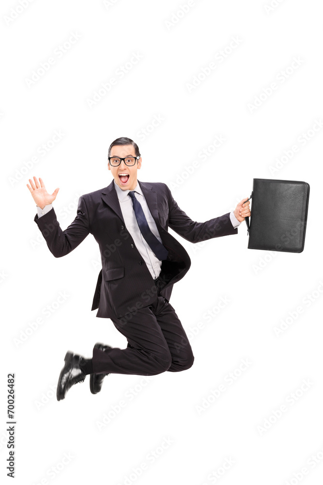 Businessman holding a case and jumping in the air