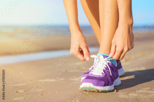 Woman wearing running shoes on the beach