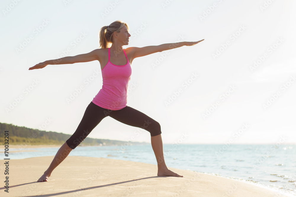Silhouette of young fit woman practicing yoga on the beach Silhouette of young fit woman practicing yoga on the beach
