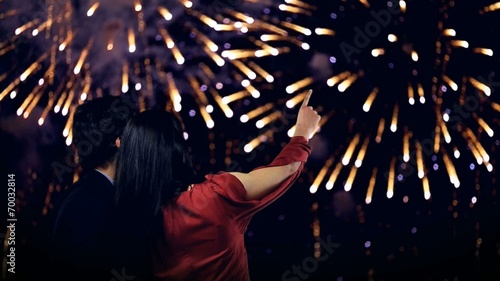 young couple looking at new year's fireworks